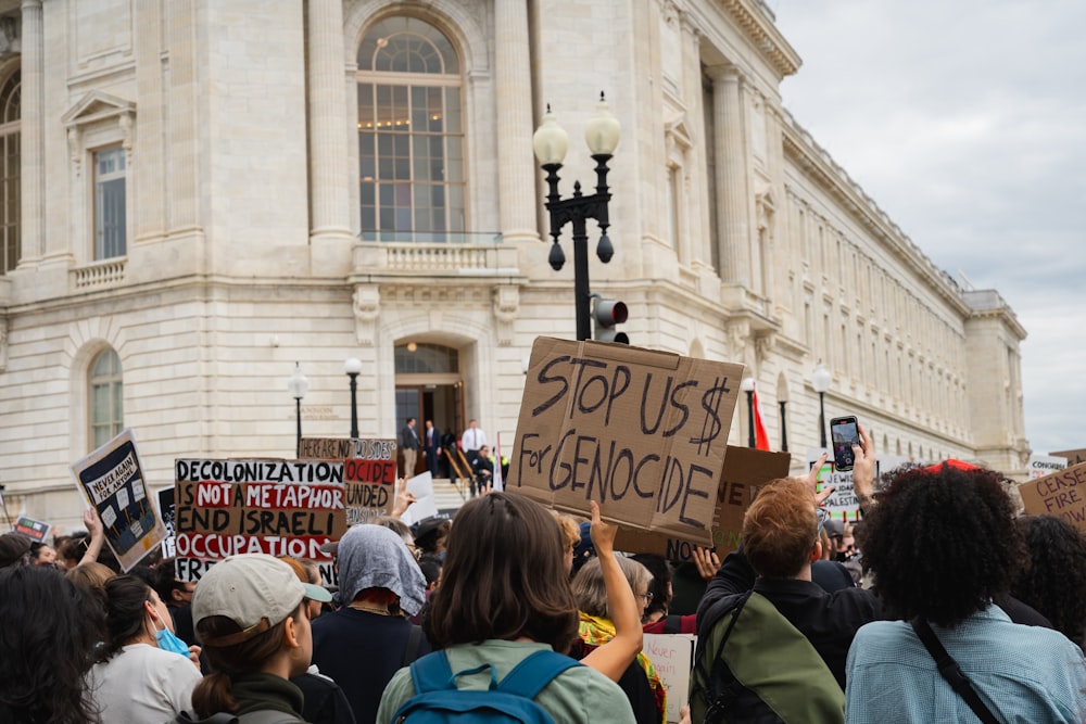 a group of people holding signs in front of a building