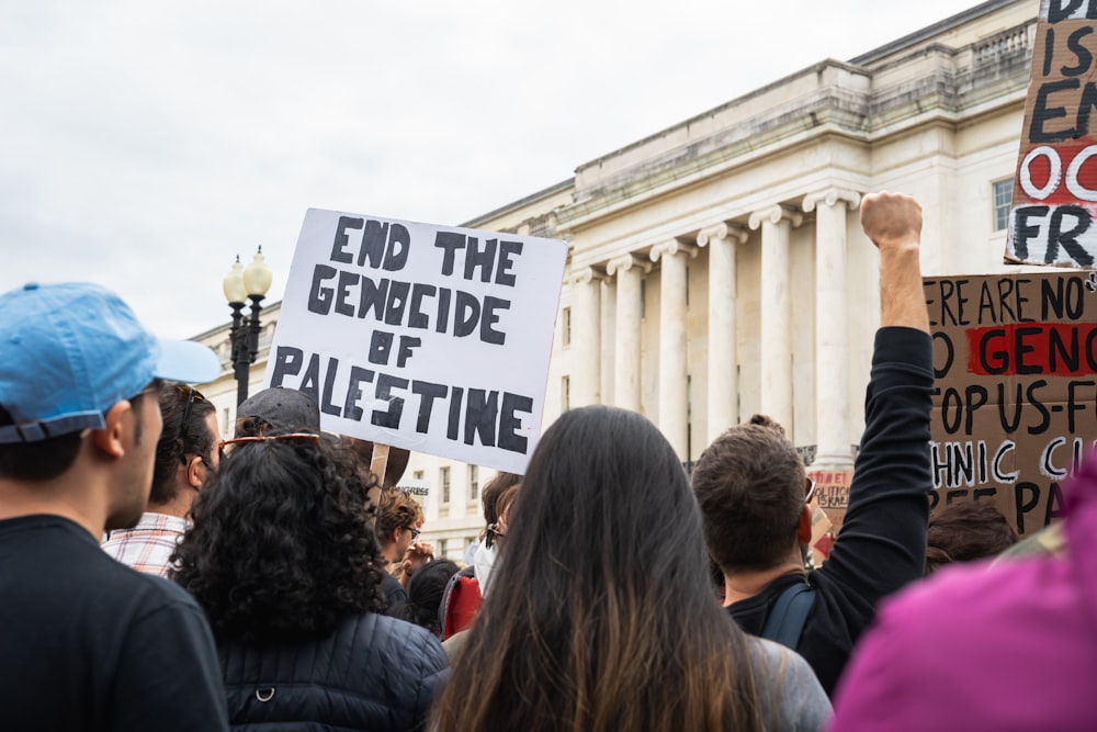 a group of people holding up signs in front of a building