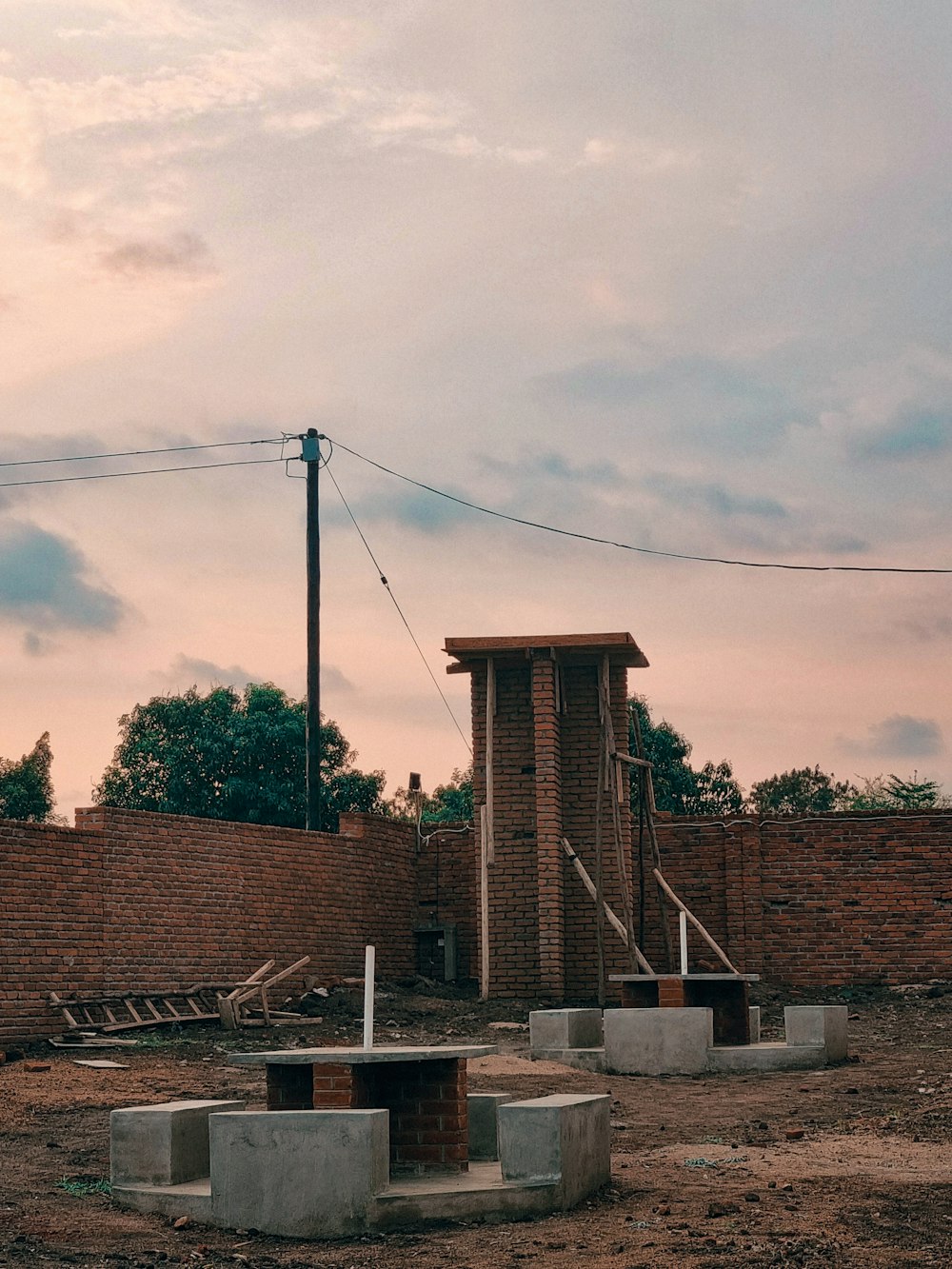 a brick structure sitting in the middle of a dirt field