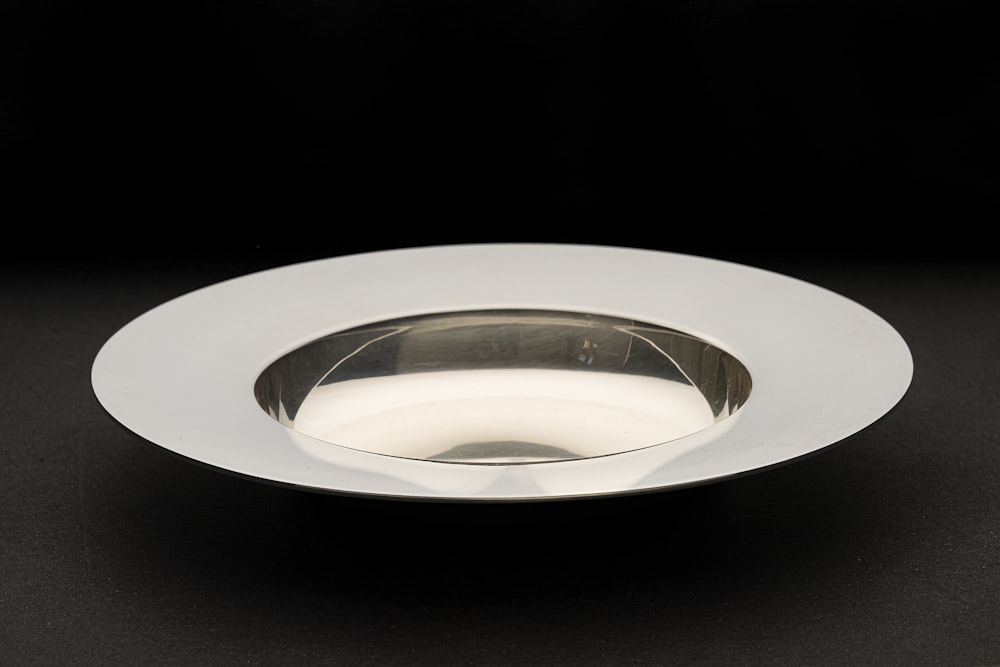 a white plate on a black table with a black background