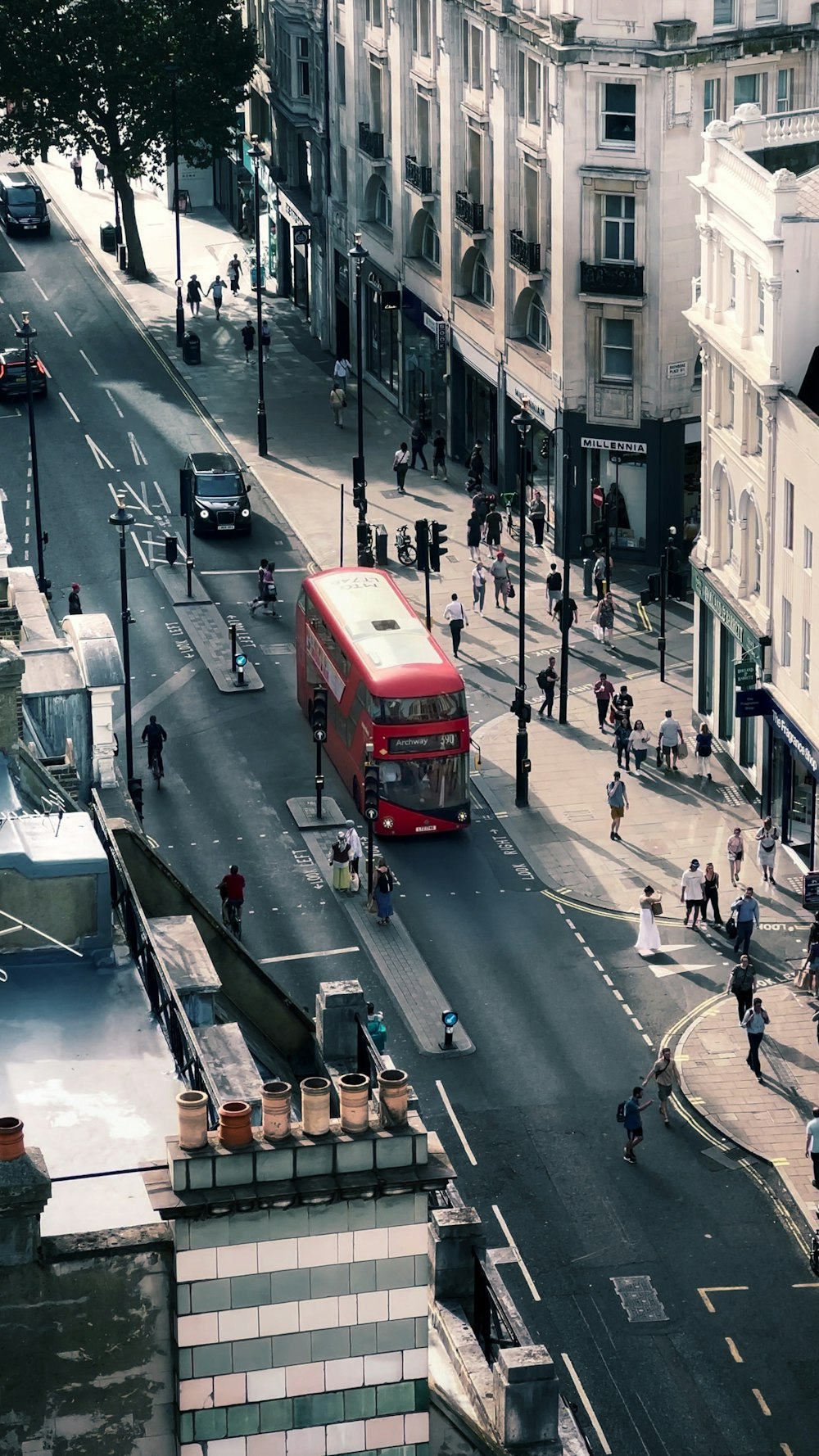 a red double decker bus driving down a city street