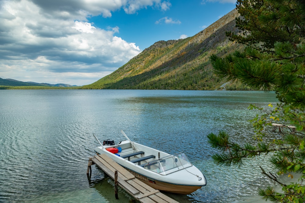 a small boat tied to a dock on a lake