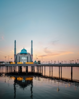 A serene view of the Blue Mosque in Istanbul at sunset, with soft golden light illuminating its domes and minarets.
