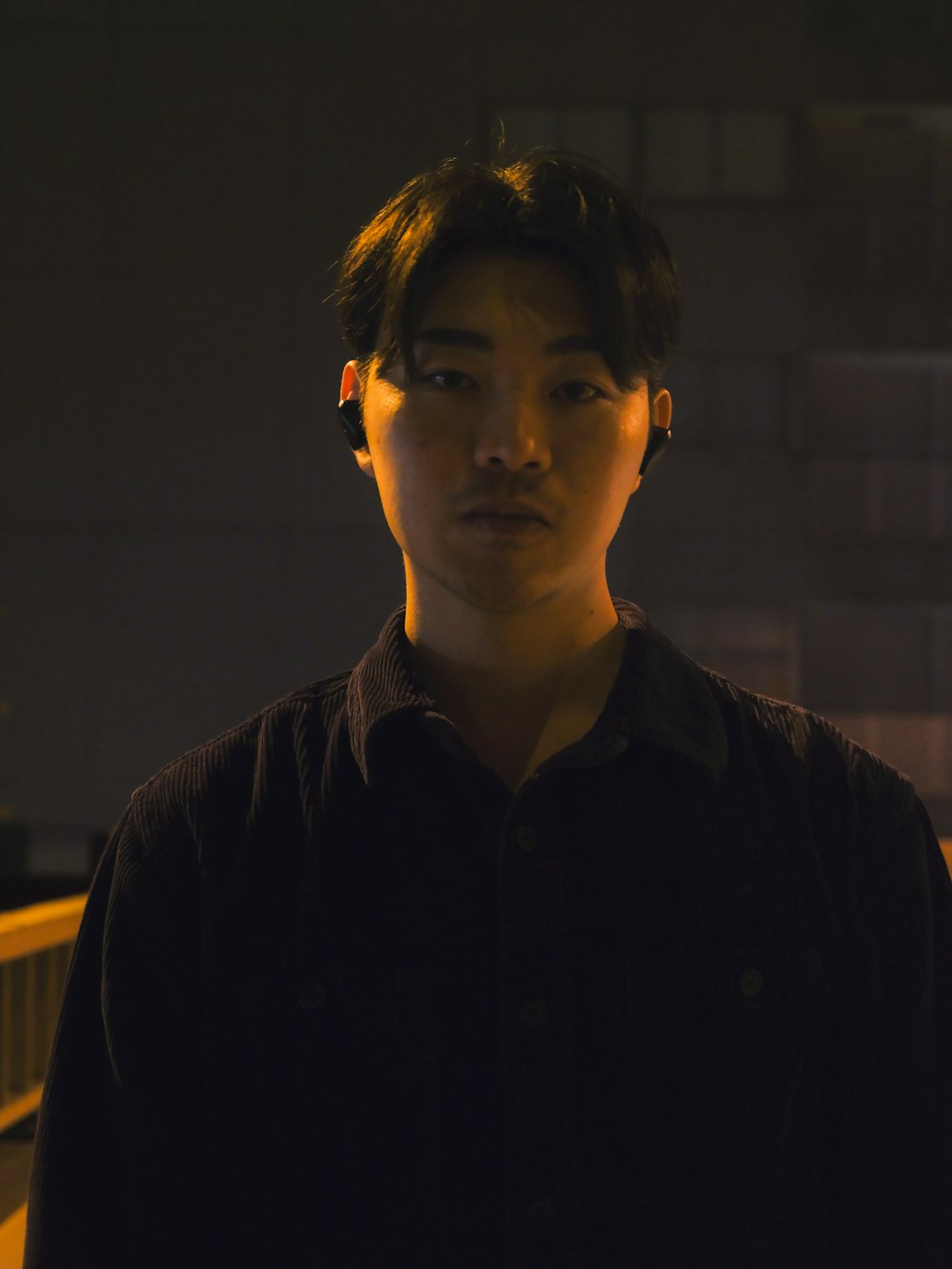 a young man standing in a dark room