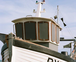 Close-up of a boat’s navigation screen displaying maps and AIS data under bright sunlight.