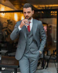 a man in a suit and tie holding a drink