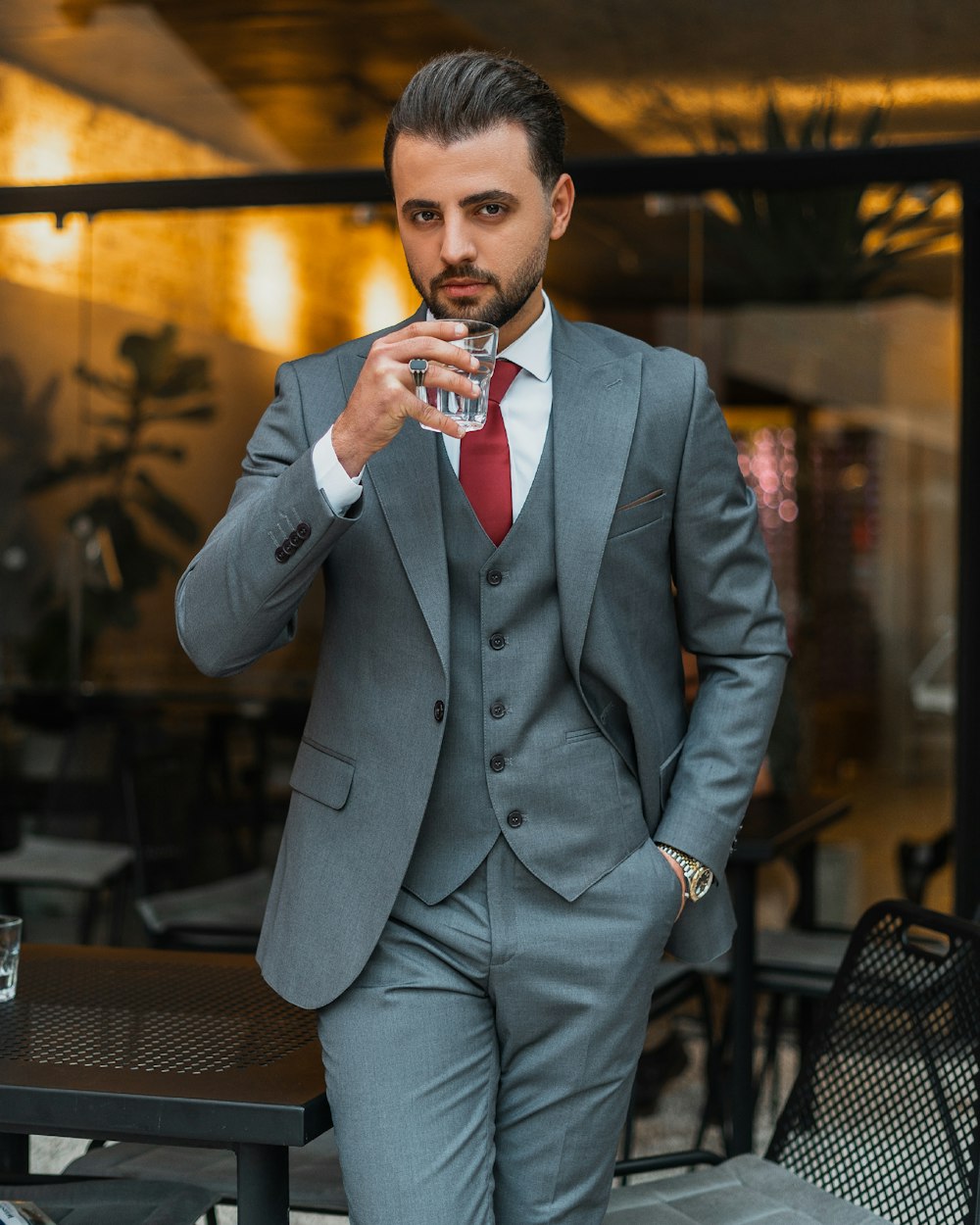 a man in a suit and tie holding a drink