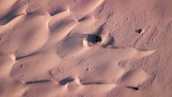 Aerial view of a quiet desert neighborhood nestled among sandy dunes.