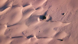 Aerial view of a quiet desert neighborhood nestled among sandy dunes.