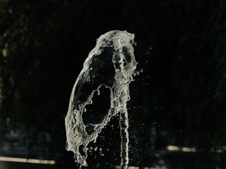 Playful splash of cloudy bongwater frozen mid-air over a wooden floor.