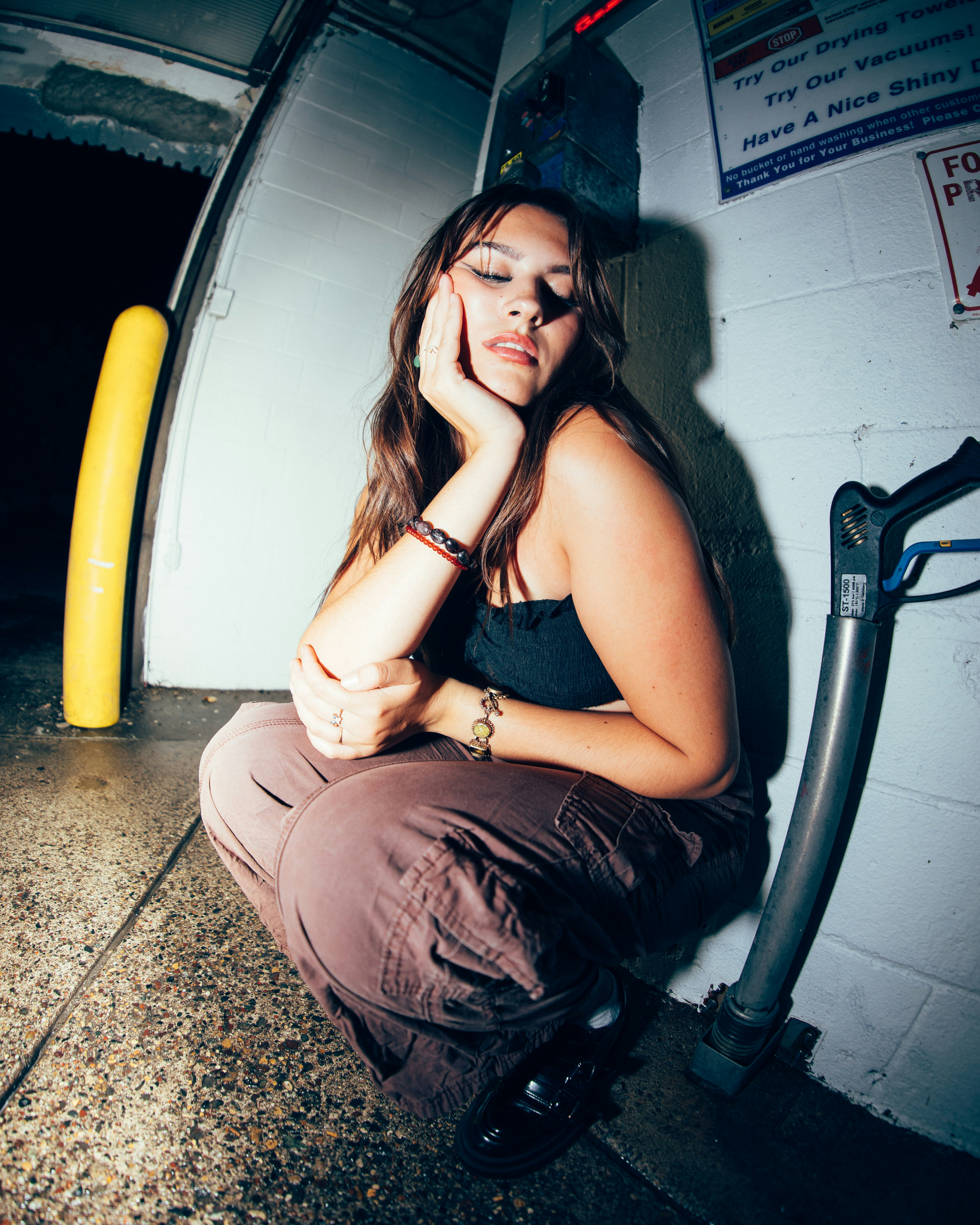 a woman sitting on the ground talking on a cell phone