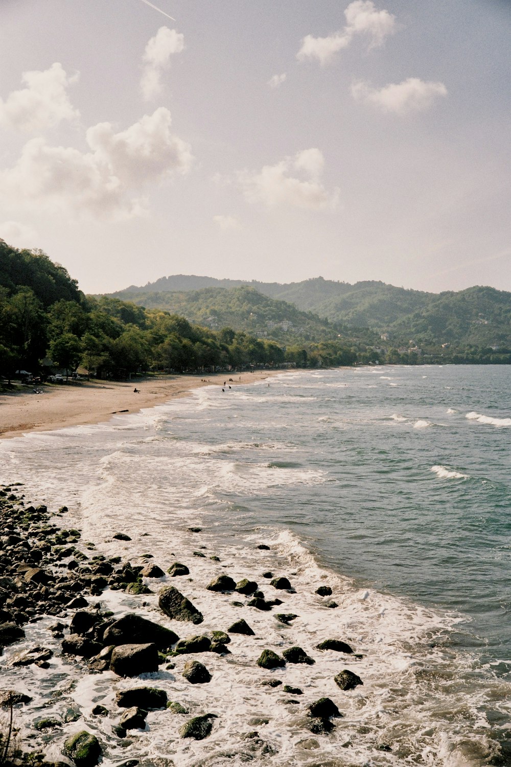 a sandy beach next to a body of water