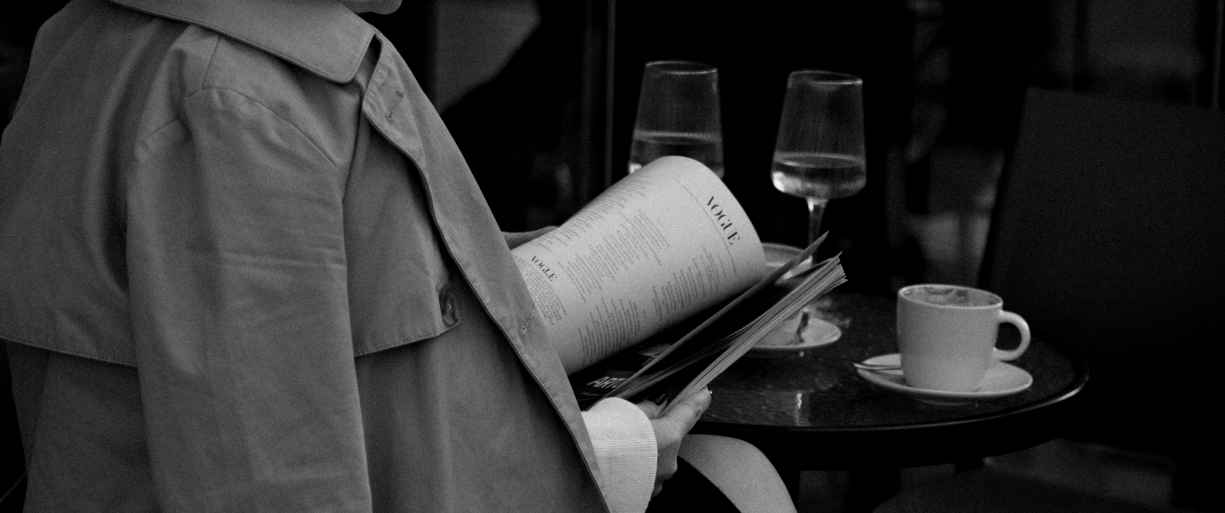 a man in a trench coat is holding a magazine