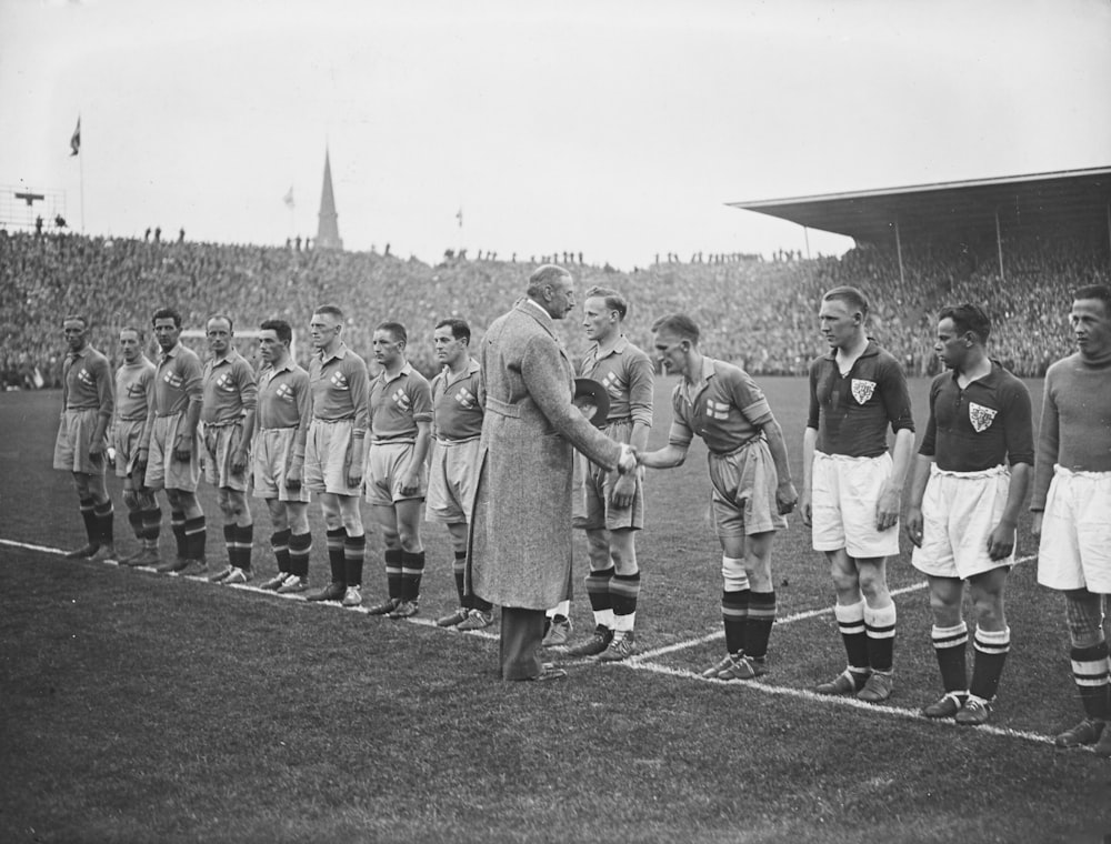 a group of men standing on top of a soccer field