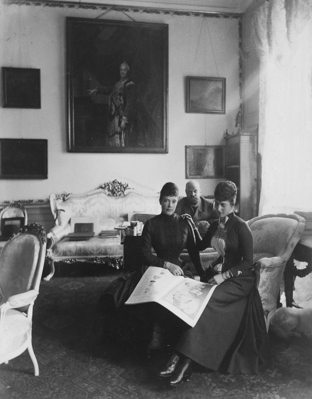 a black and white photo of two women sitting in a living room