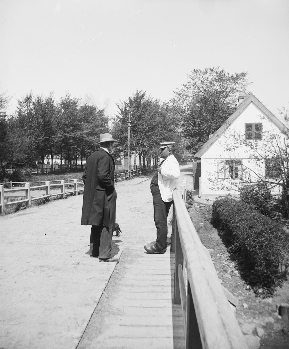 a couple of men standing on top of a bridge