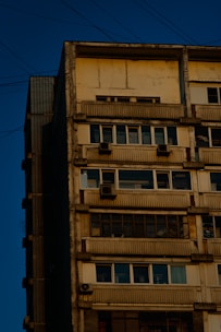 Apartment building exterior with maintenance worker checking electrical systems.