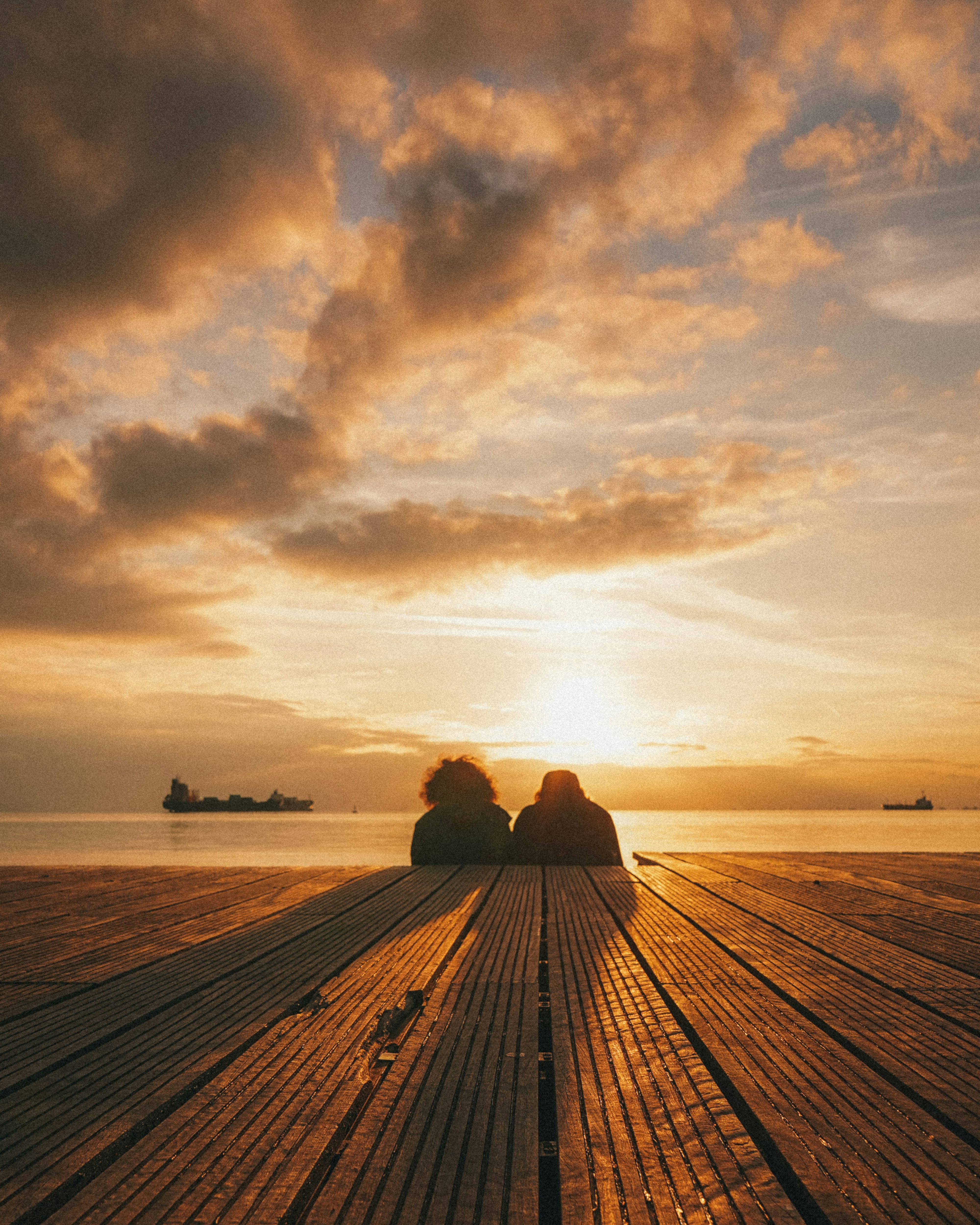 a couple of benches sitting on top of a wooden pier