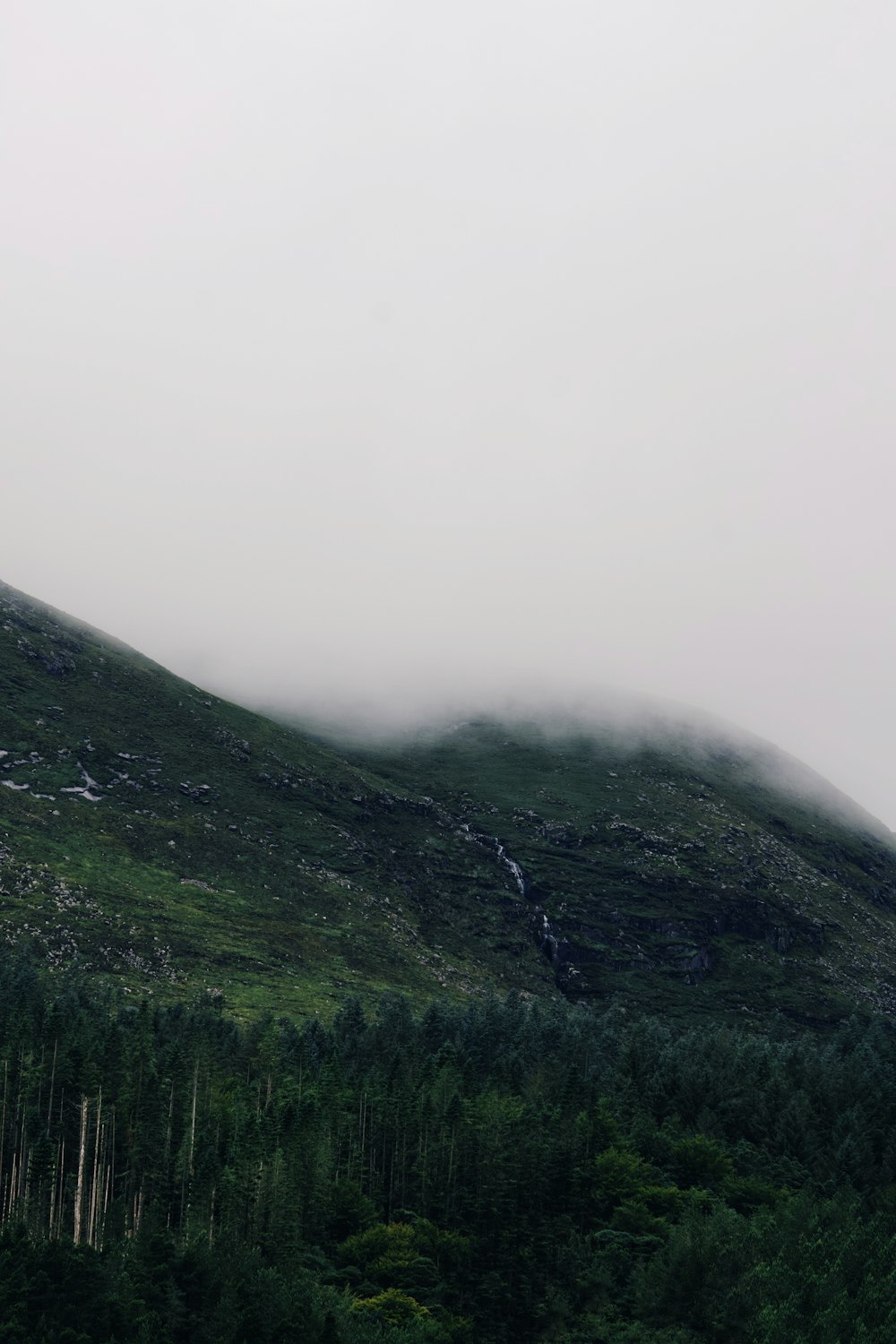 ein Berg, der in Nebel gehüllt ist und tief hängende Wolken