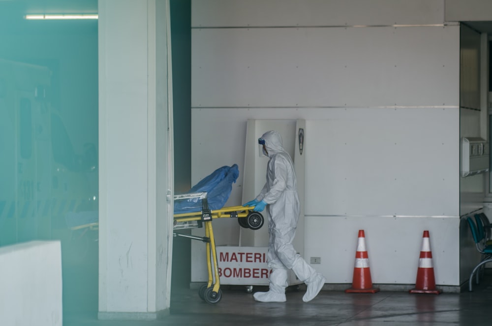 a person in a hazmat carrying a cart