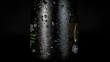 Close-up of a matte black Senna bottle glowing under neon yellow light with water droplets.