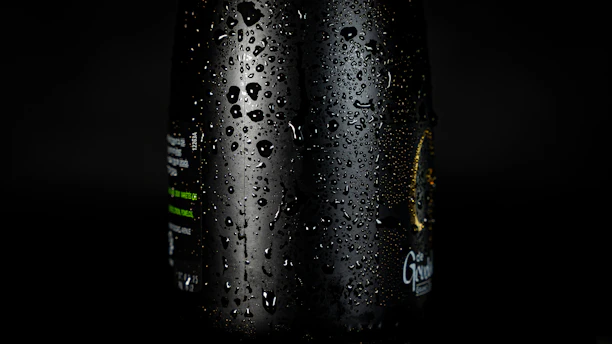 A close-up of a sleek Coolzy bottle with morning dew, resting on a wooden picnic table bathed in soft sunlight.