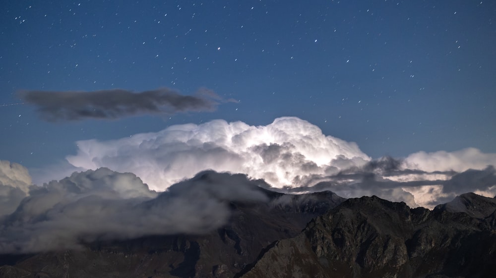 the night sky is full of clouds and stars