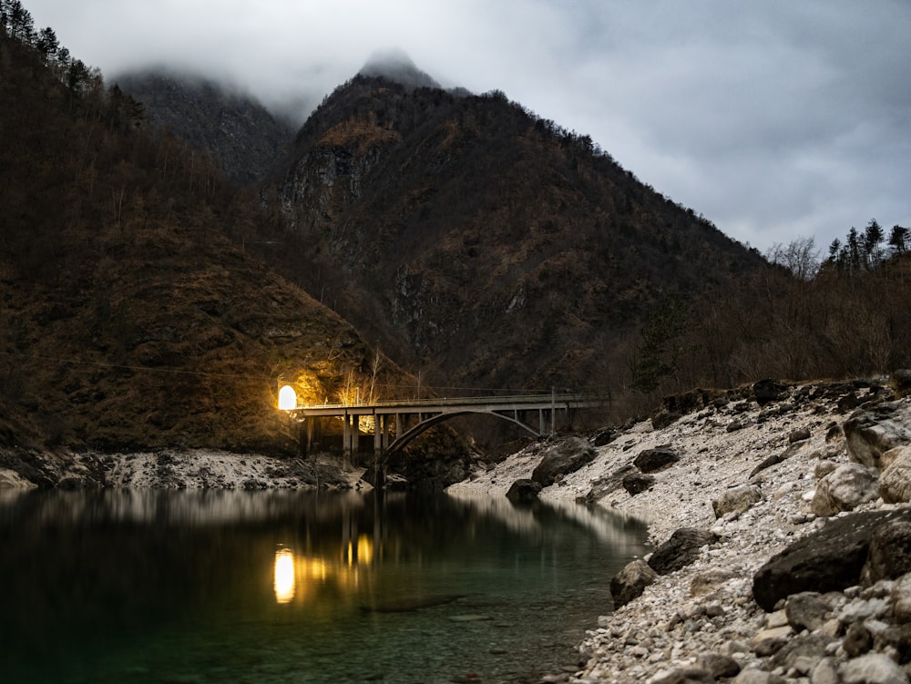 a bridge over a body of water with a mountain in the background