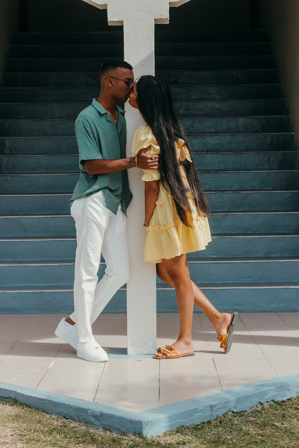 a man and a woman kissing in front of a cross