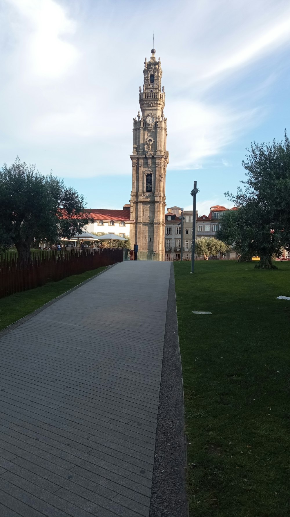 una grande torre dell'orologio che domina un lussureggiante parco verde