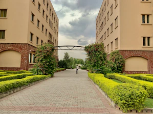 a person walking down a brick walkway between two buildings