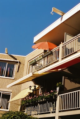 A friendly installer measuring a balcony for a custom awning under a bright sky.