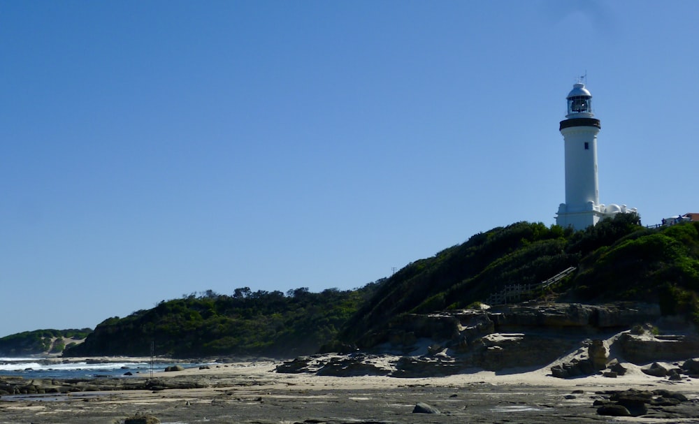 a light house on a hill overlooking the ocean