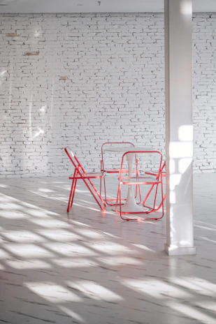 Interior view of a minimalist living space featuring clean lines, natural light, and subtle red accents.