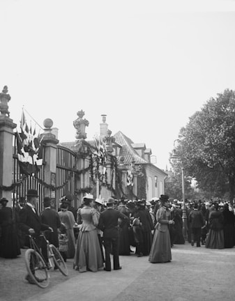 A solemn ceremonial gathering of members dressed in elegant regalia under historic arches.