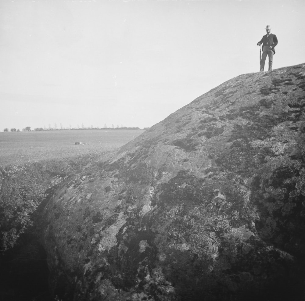 a man standing on top of a large rock