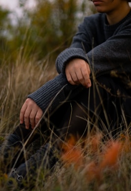 a person sitting in a field of tall grass