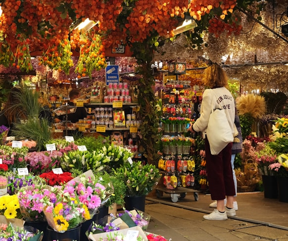 a woman standing in front of a flower shop