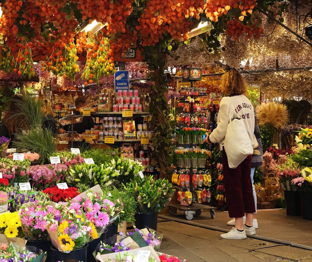 a woman standing in front of a flower shop