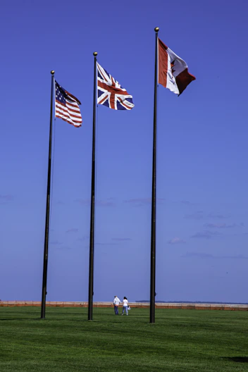 a group of three flags flying next to each other