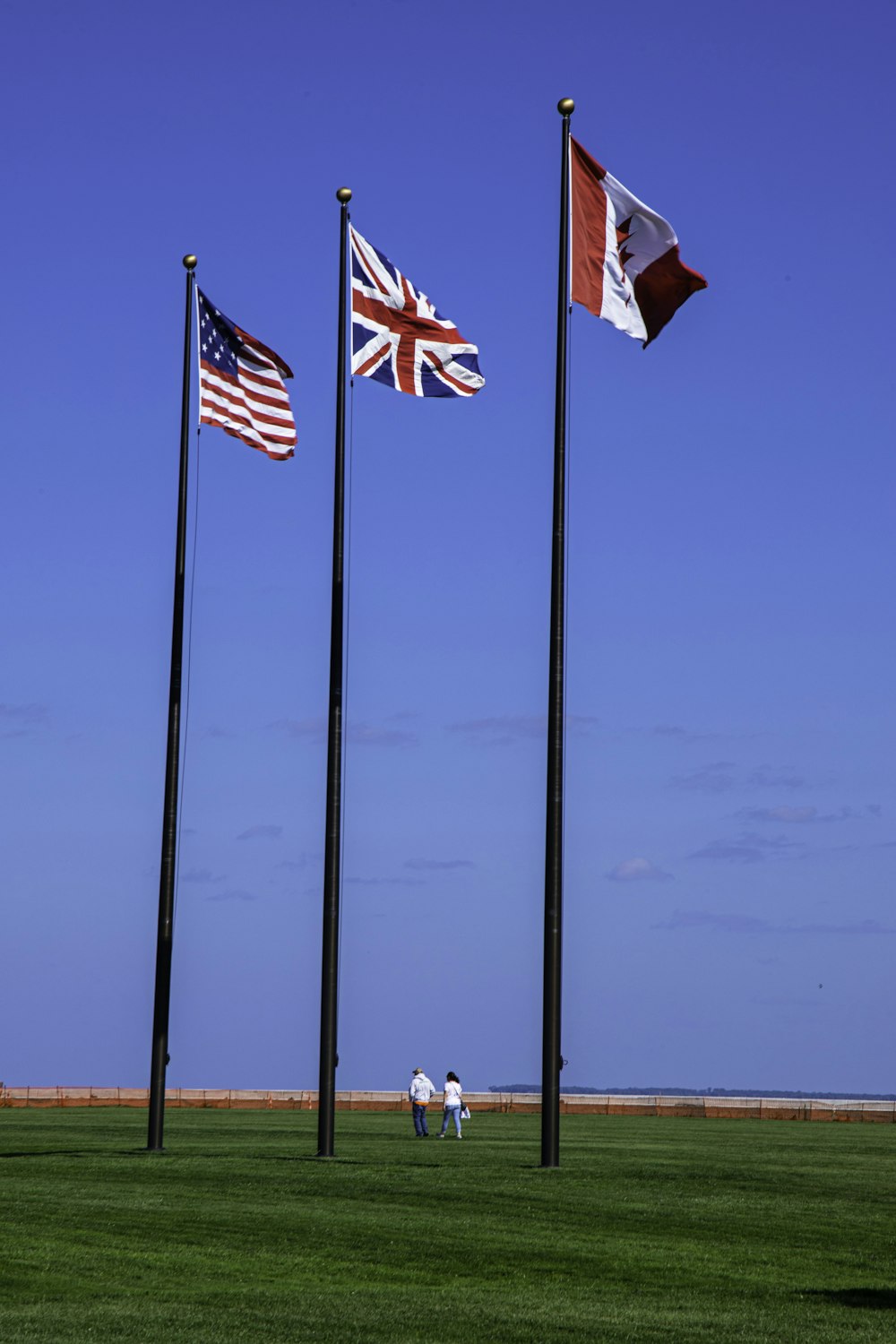 a group of three flags flying next to each other