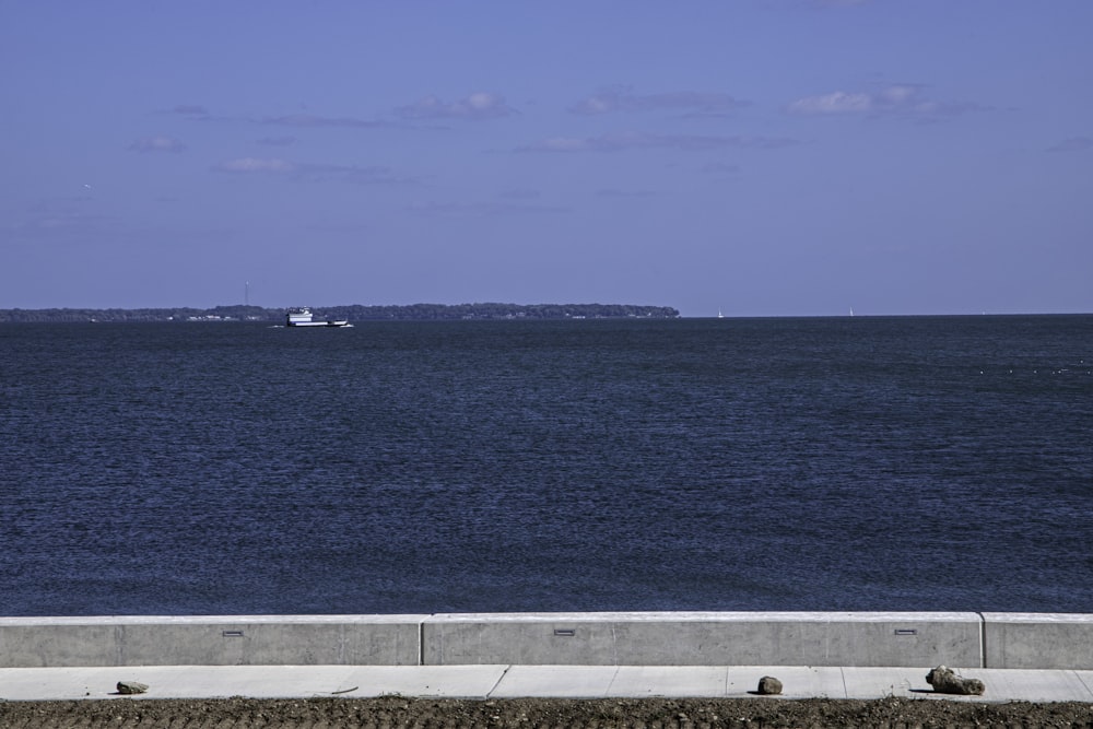 a large body of water with a boat in the distance