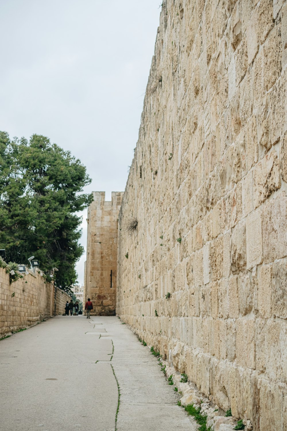 a stone wall that is next to a sidewalk