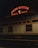 A vintage train car is parked at a station under a neon sign that reads 'Union Station Travel by Train'. The train car is labeled 'Pullman' and 'Suitsme', with a classic design typical of early 20th-century railcars.