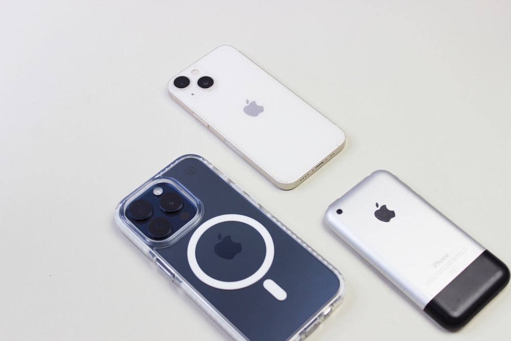 three cell phones sitting next to each other on a table