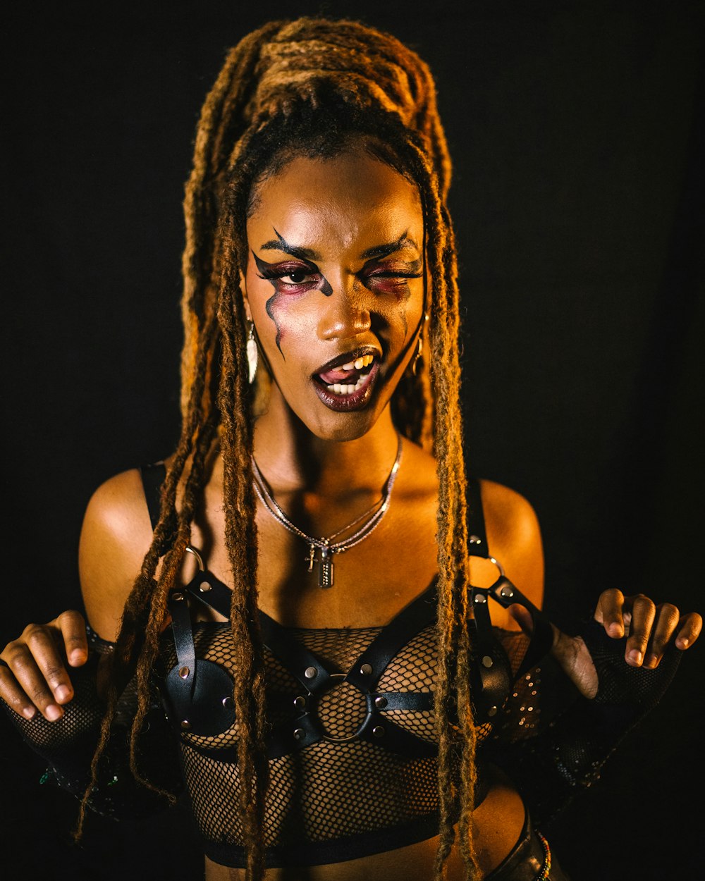 a woman with makeup on her face and dreadlocks