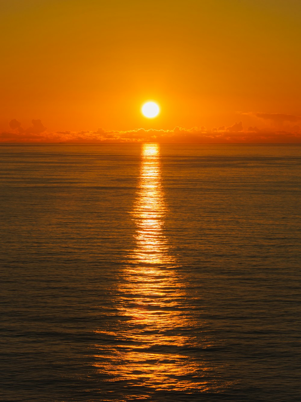 a large body of water with a sunset in the background