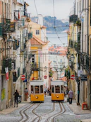 a couple of yellow trolleys driving down a street