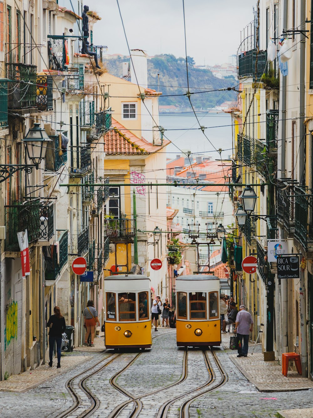 a couple of yellow trolleys driving down a street