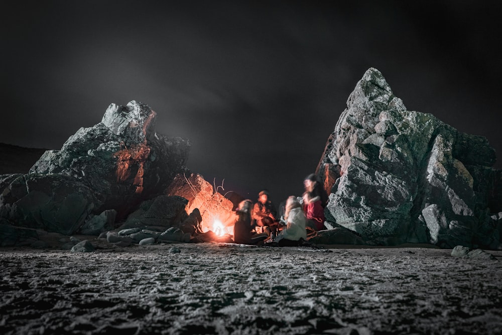 a group of people sitting around a campfire